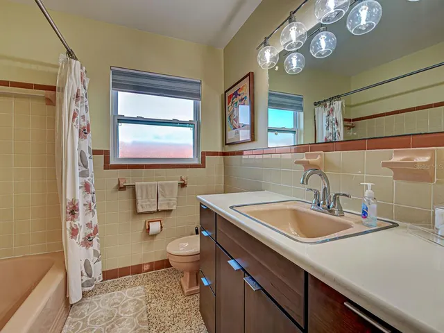 a bathroom with a sink a toilet and a mirror