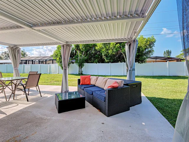 a view of a patio with a table chairs and a swimming pool