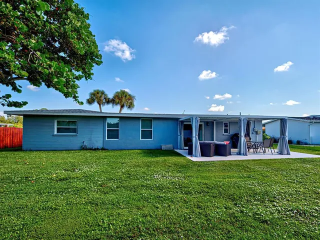 a view of a house with a yard and sitting area