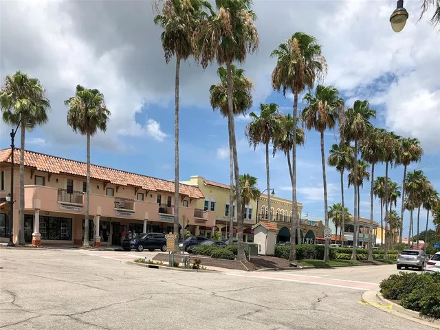 a front view of multiple building with palm trees