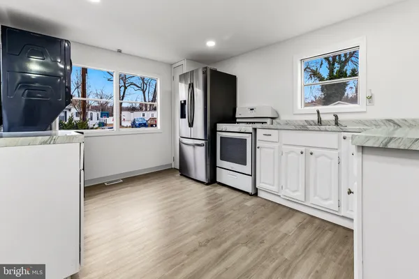 a kitchen with stainless steel appliances granite countertop a refrigerator and a stove top oven