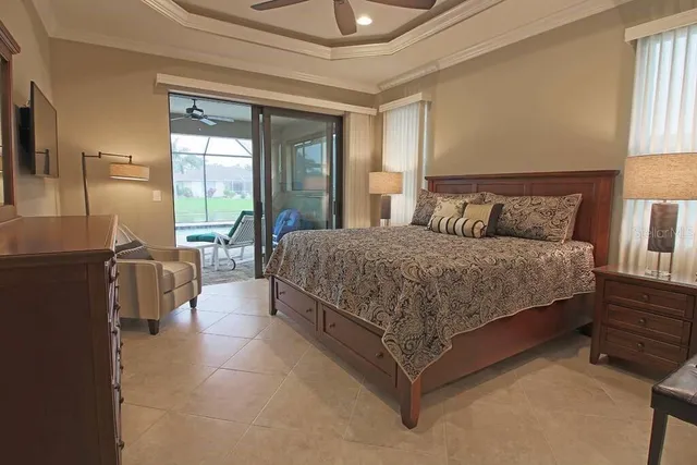 a bedroom with a bed couch and a large window