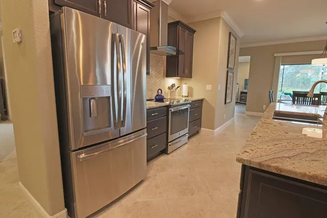 a kitchen with stainless steel appliances granite countertop a refrigerator and a sink