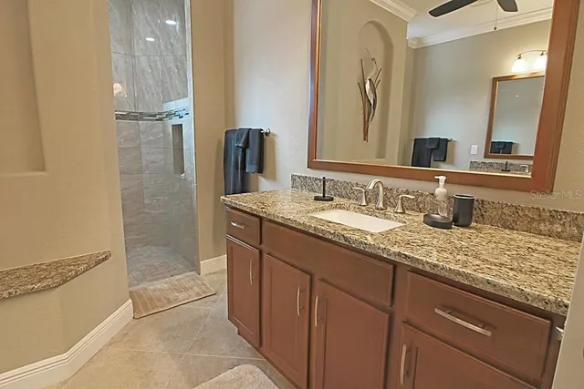 a bathroom with a granite countertop bathtub shower sink vanity and mirror
