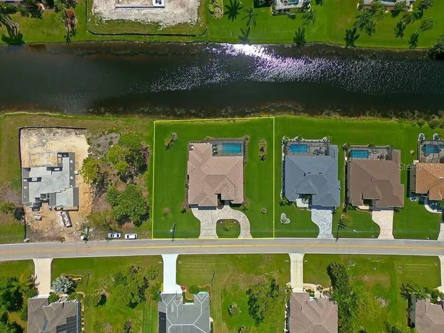 an aerial view of a swimming pool with a yard