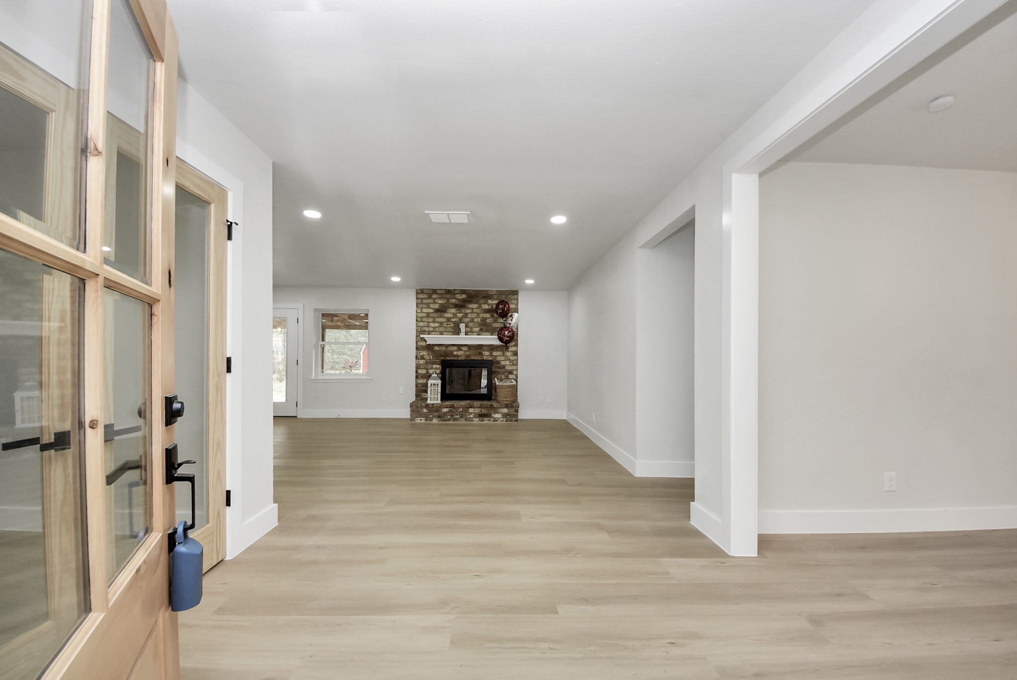 26206 Maplewood Drive Spring, TX 77386 - Photo 6 of 47 a view of an empty room with wooden floor and a kitchen