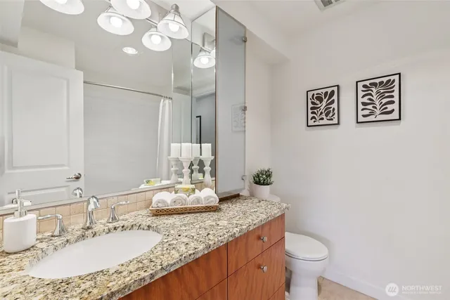 a bathroom with a granite countertop sink and a mirror
