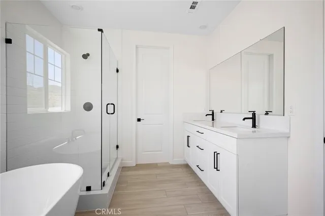 a bathroom with a double vanity sink a toilet and shower