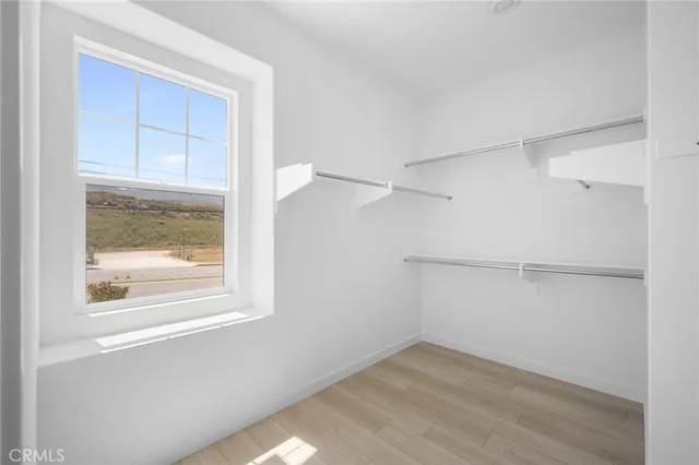 a view of a small space with wooden floor and a window