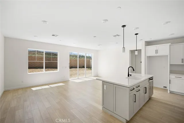 a spacious white kitchen with a sink and a large window