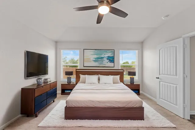 a bedroom with a bed and a flat screen tv