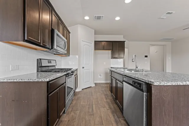 a kitchen with granite countertop stainless steel appliances and wooden cabinets