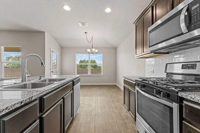 a kitchen with stainless steel appliances granite countertop a stove and a sink