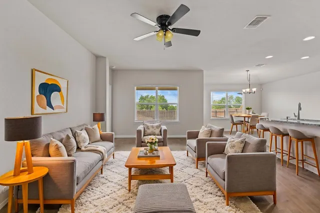 a living room with furniture kitchen view and a window