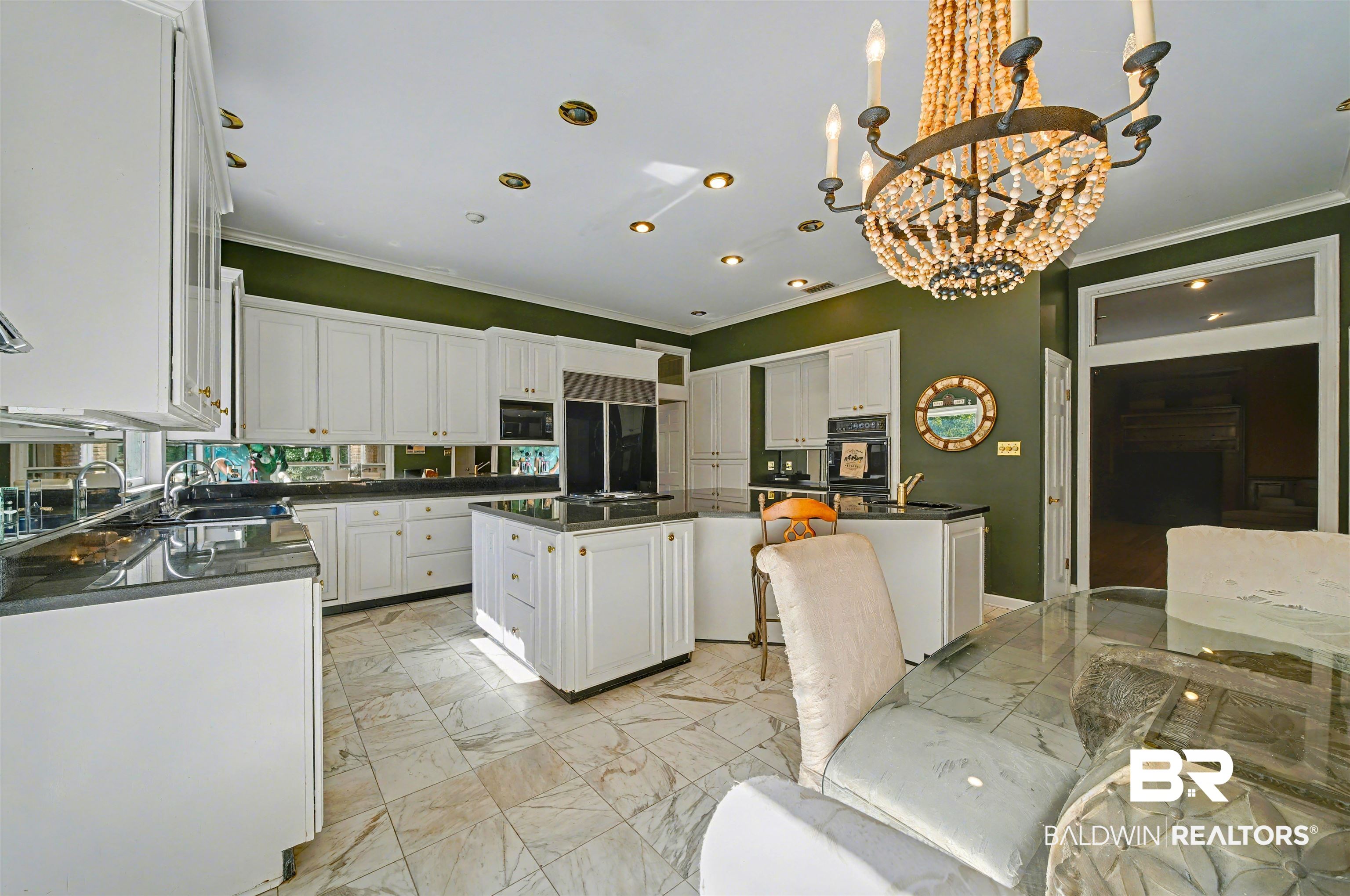 15810 County Road 73 Foley, AL 36535 - Photo 19 of 56 Kitchen featuring light marble finish flooring, a kitchen island, crown molding, white cabinetry, and a chandelier