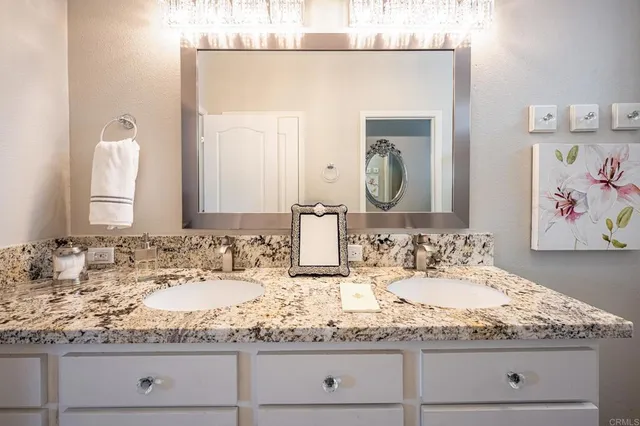 a bathroom with a granite countertop sink and a mirror