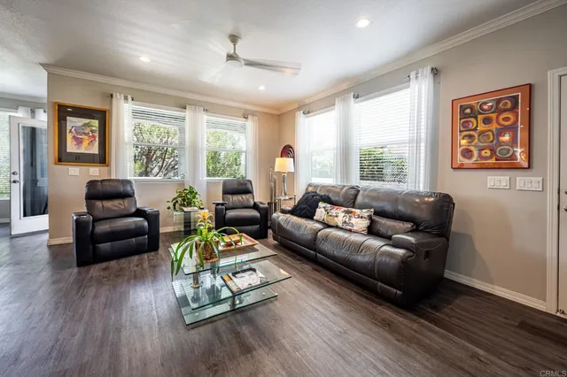 a living room with furniture and a wooden floor