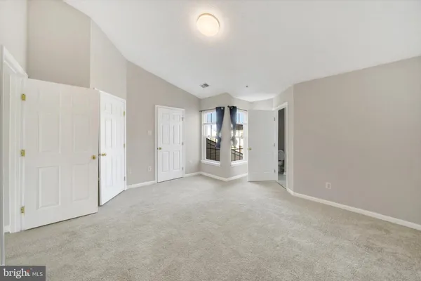 an empty room with a cabinet and mirrors