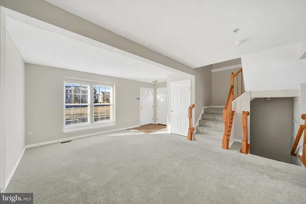 a view of empty room with wooden floor and window