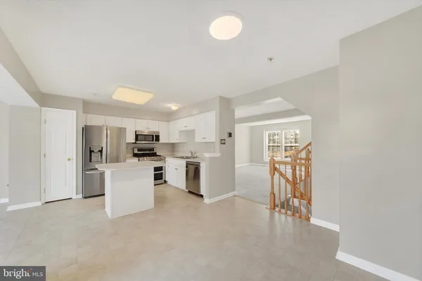 a view of kitchen with furniture and refrigerator