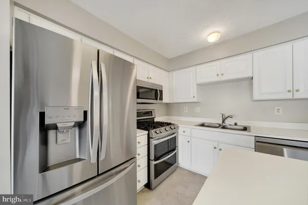 a kitchen with stainless steel appliances a refrigerator sink and cabinets