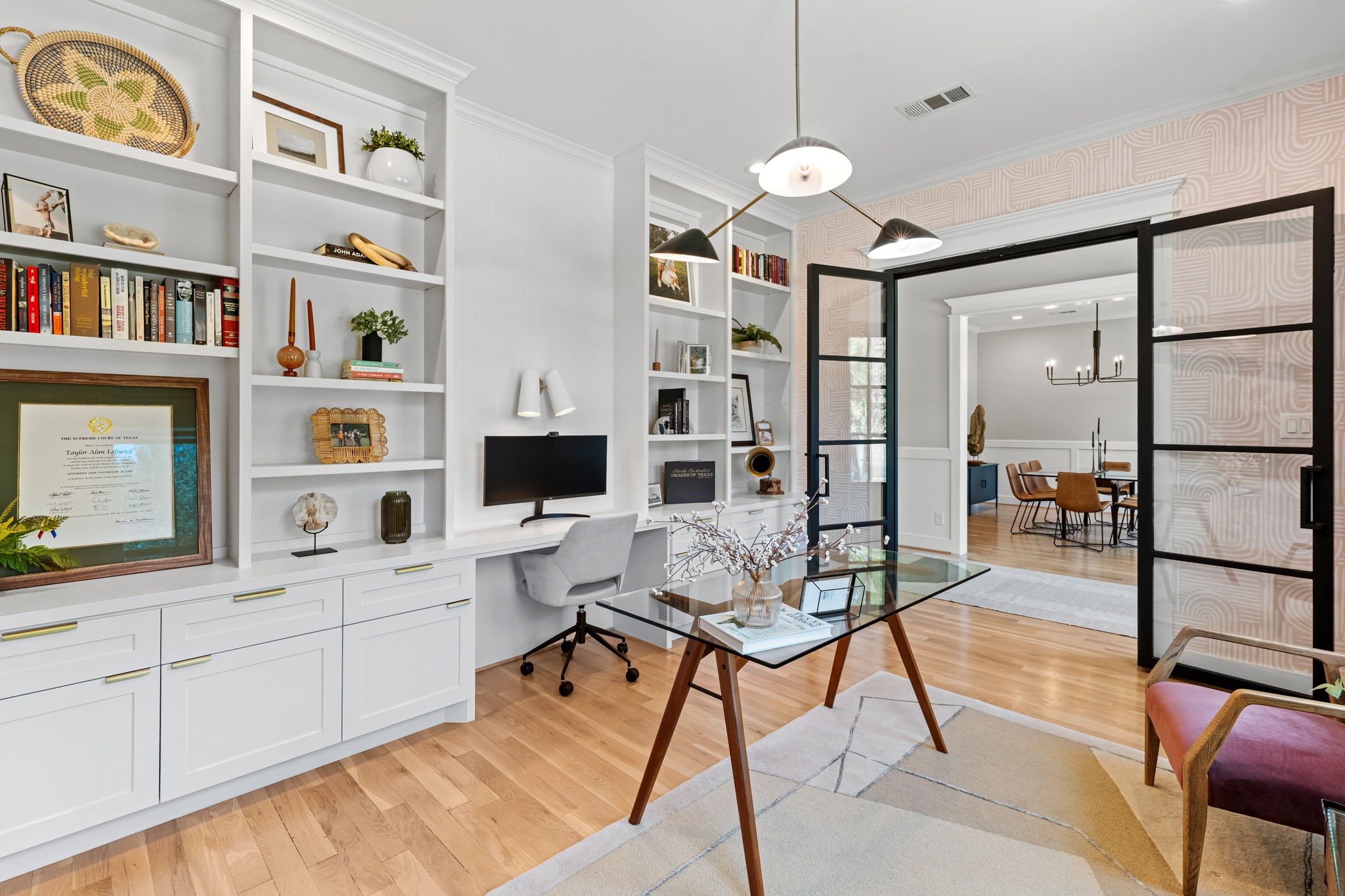 1013 Martin Street Houston, TX 77018 - Photo 8 of 46 Thoughtfully designed formal study w/wall of custom built-ins including display shelving, cabinetry, drawers, & workspace accented by elegant wallpaper, and a decorative wall sconce light fixture. Notice the double iron doors.