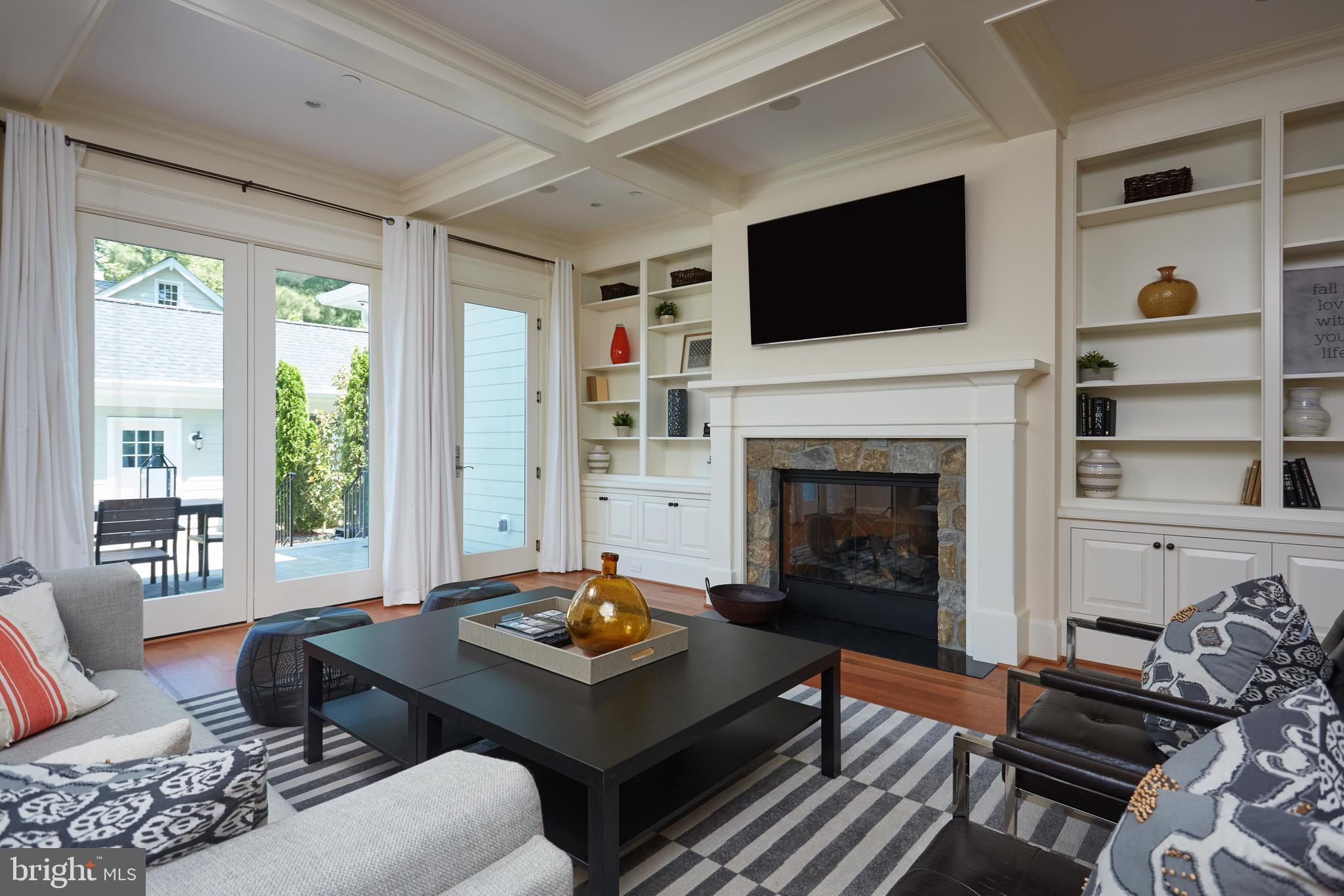 8003 Maple Ridge Road Bethesda, MD 20814 - Photo 9 of 30 a living room with furniture a flat screen tv and a fireplace