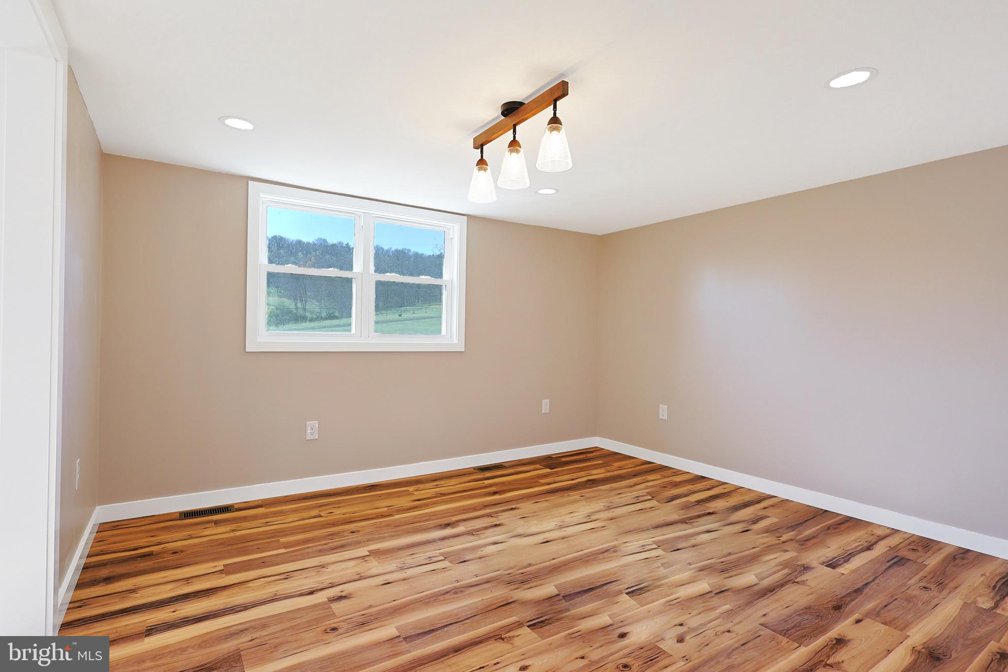 502 Sol Shanholtz Road Augusta, WV 26704 - Photo 17 of 61 wooden floor in an empty room with a window