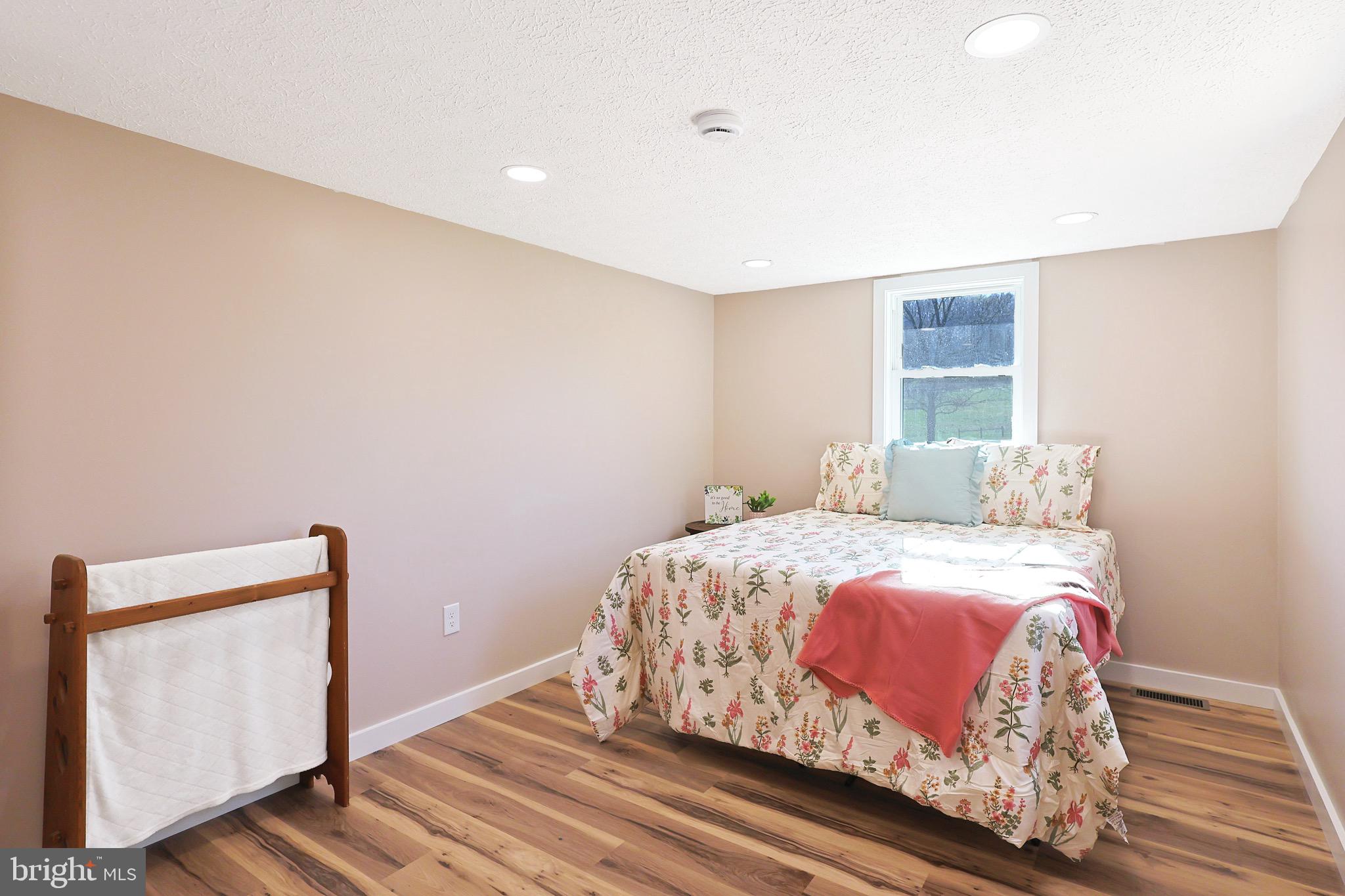 502 Sol Shanholtz Road Augusta, WV 26704 - Photo 32 of 61 a bedroom with a bed and wooden floor