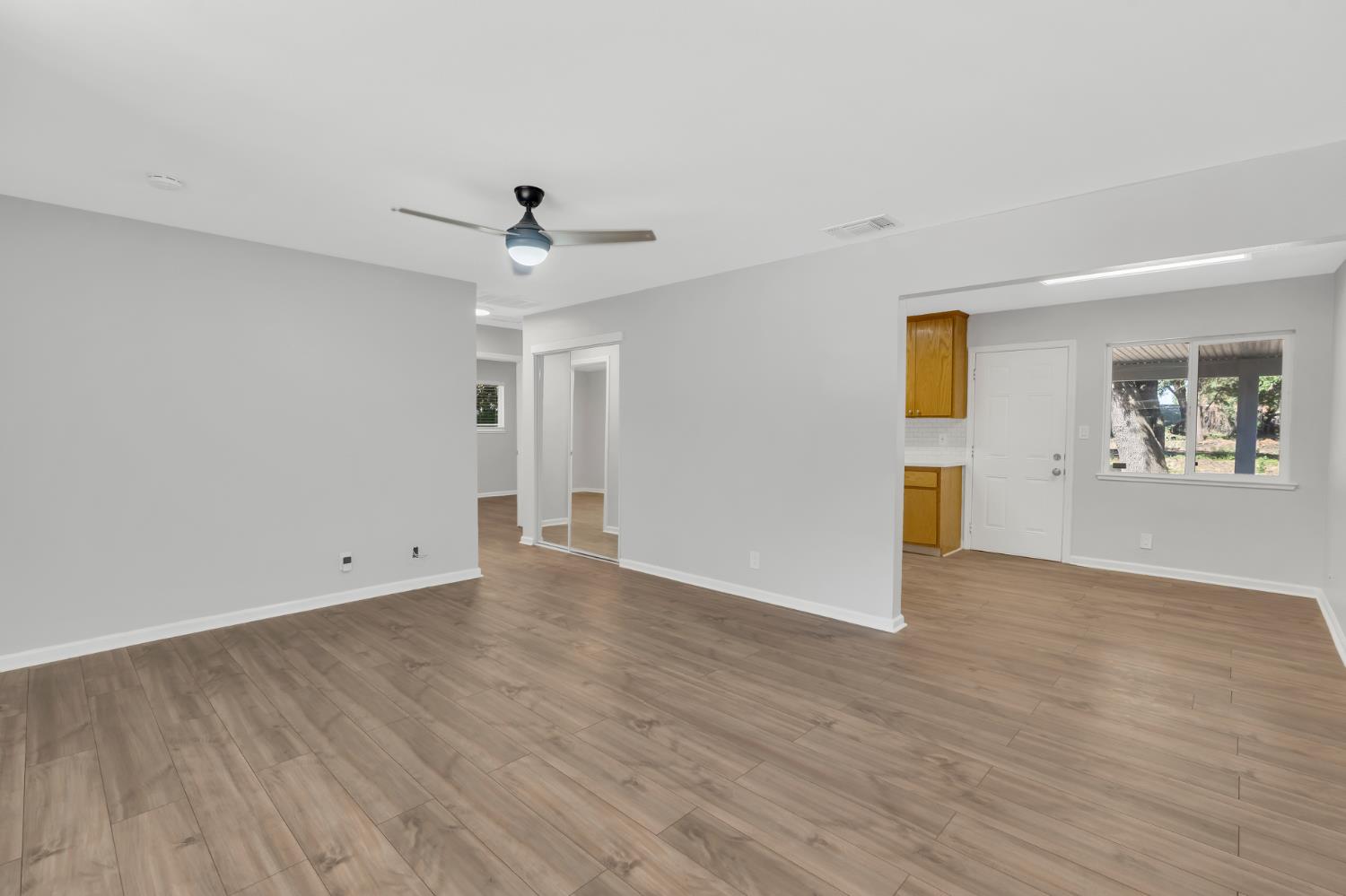 5720 Riverside Boulevard Sacramento, CA 95822 - Photo 38 of 54 an empty room with wooden floor ceiling fan and windows
