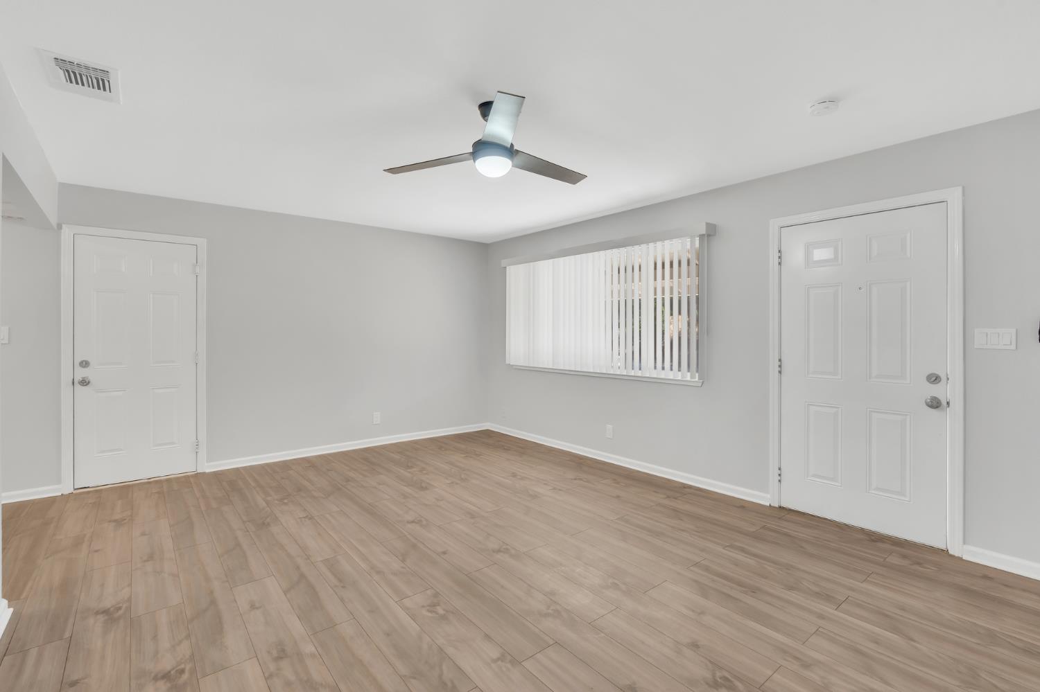 5720 Riverside Boulevard Sacramento, CA 95822 - Photo 39 of 54 an empty room with wooden floor ceiling fan and windows