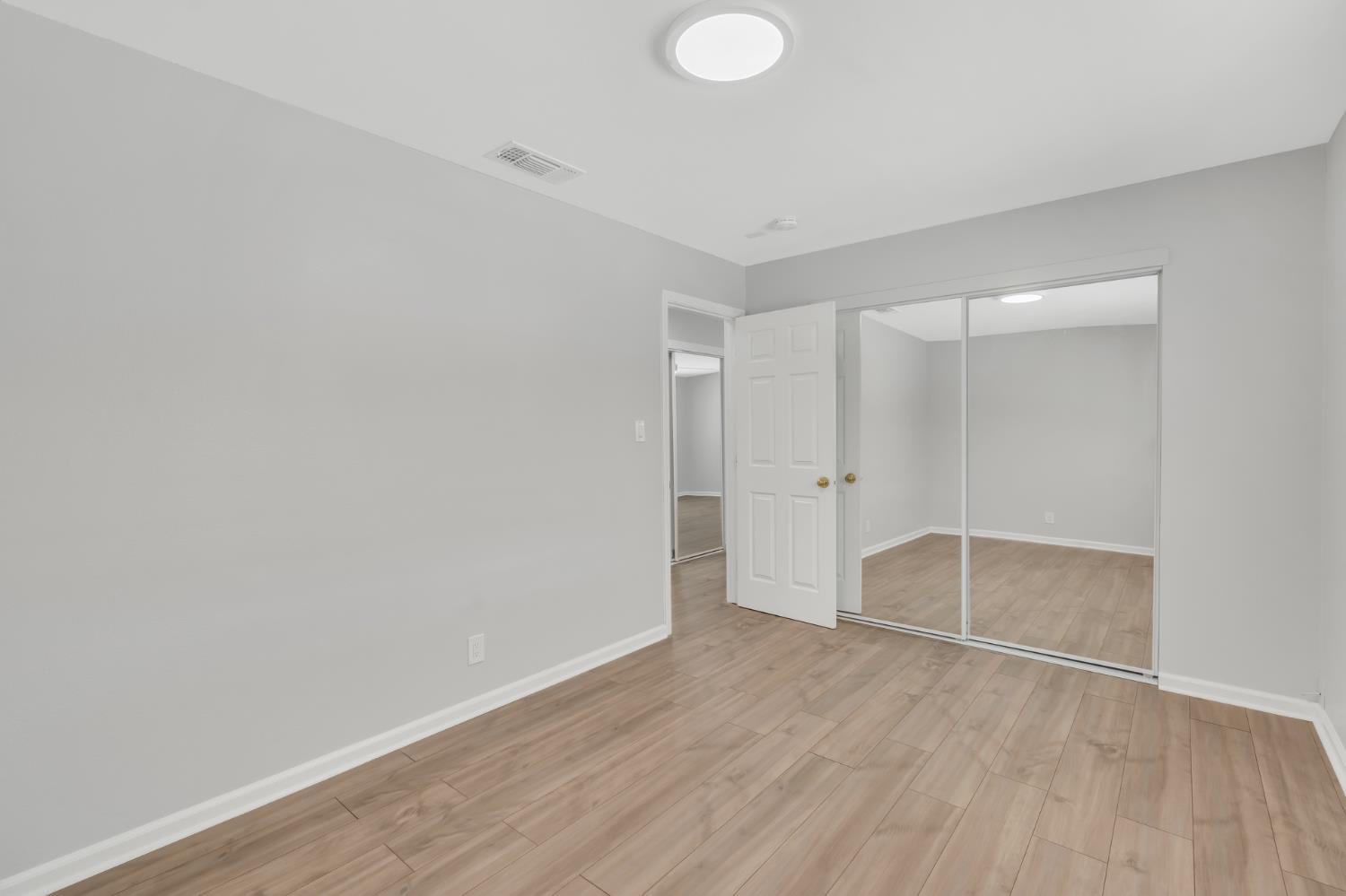 5720 Riverside Boulevard Sacramento, CA 95822 - Photo 45 of 54 an empty room with wooden floor and white walls