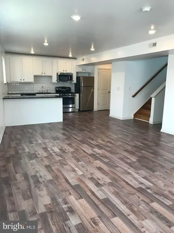 a view of kitchen with kitchen island microwave and cabinets