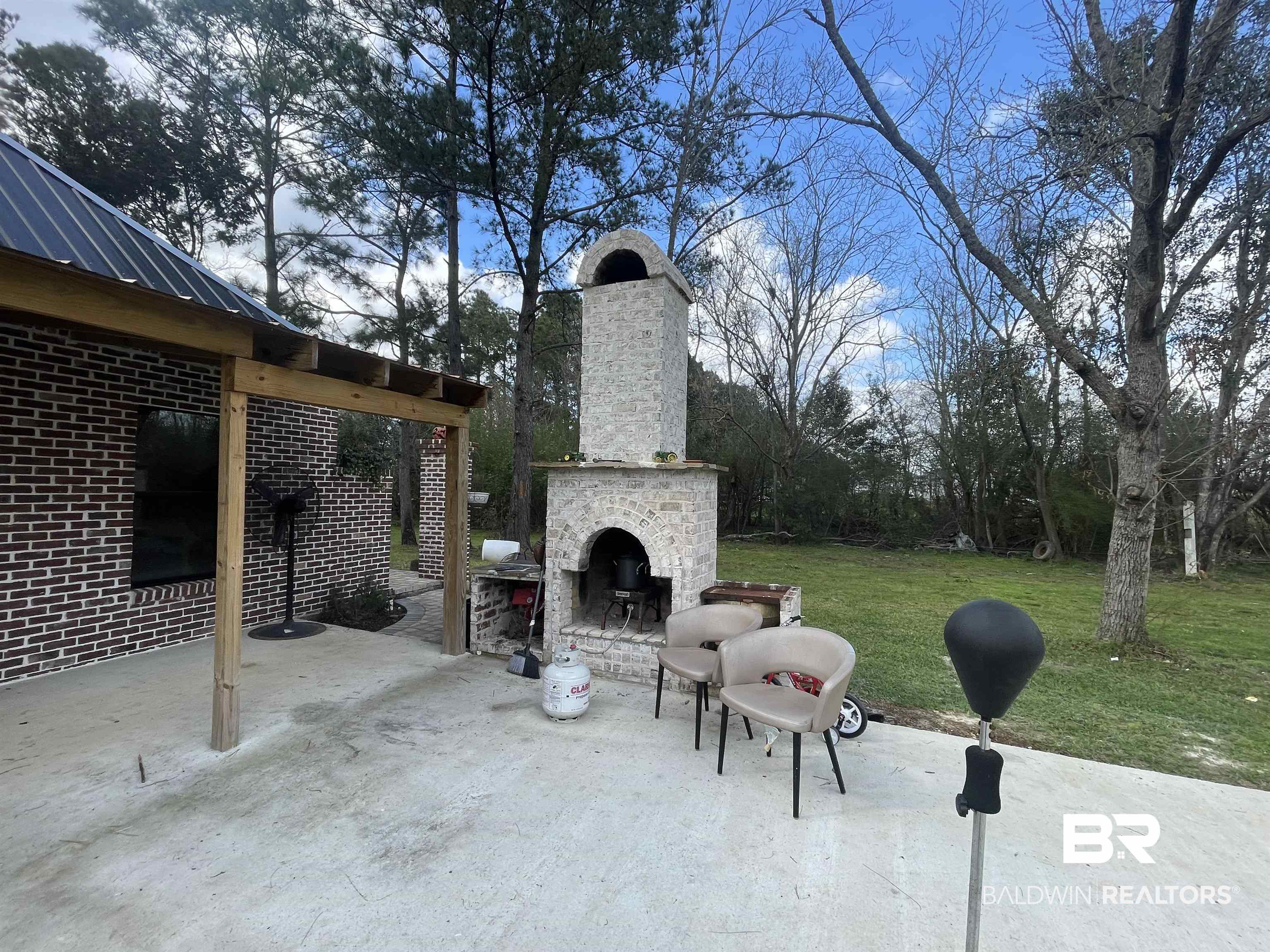 21593 Hubbard Road Robertsdale, AL 36567 - Photo 20 of 22 View of patio with an outdoor brick fireplace
