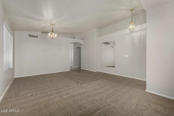 an empty room with wooden floor and mirror