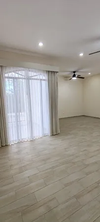 an empty room with a ceiling fan and window