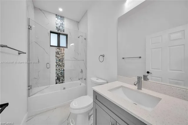 a bathroom with a sink toilet vanity and shower
