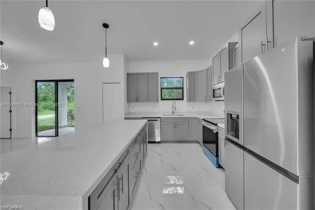 a kitchen with stainless steel appliances a refrigerator sink and stove