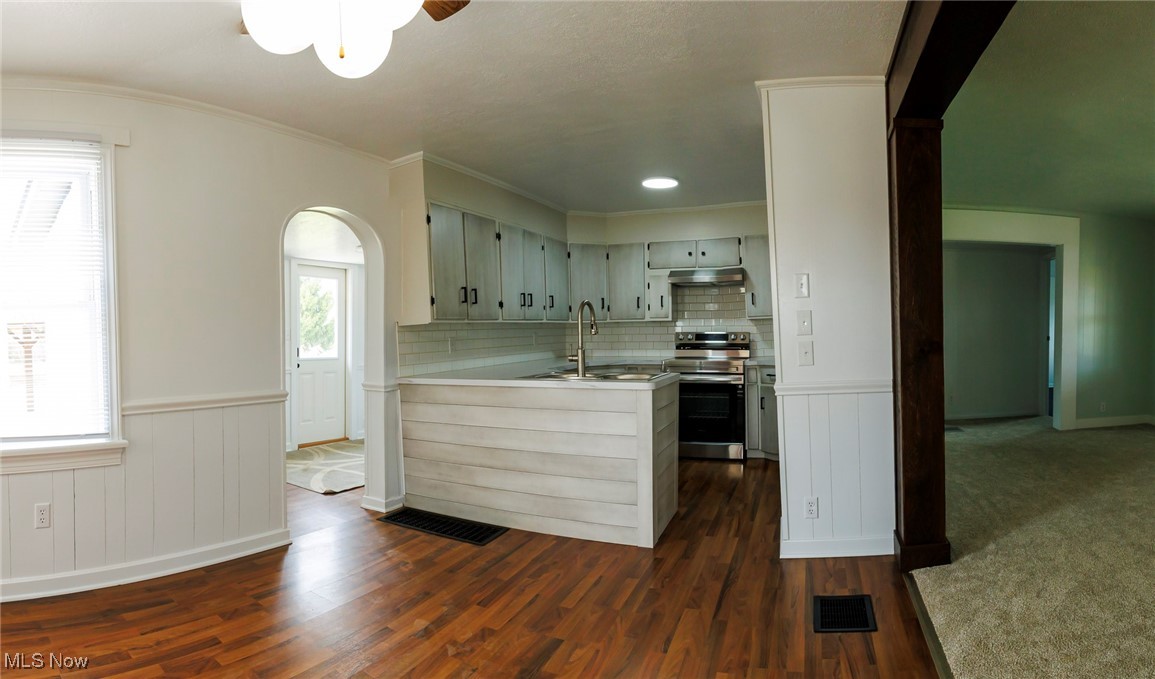 13239 Navarre Road Southwest Beach City, OH 44608 - Photo 8 of 48 Kitchen featuring electric stove, a peninsula, under cabinet range hood, a sink, and dark wood-style floors