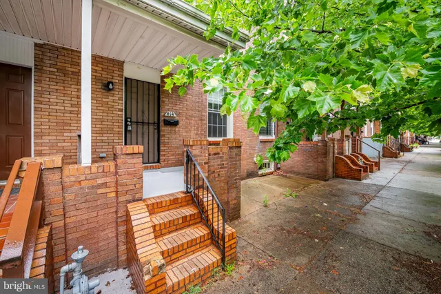 a view of a patio with table and chairs potted plants and large tree