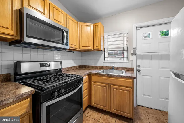 a kitchen with stainless steel appliances granite countertop a stove and a microwave