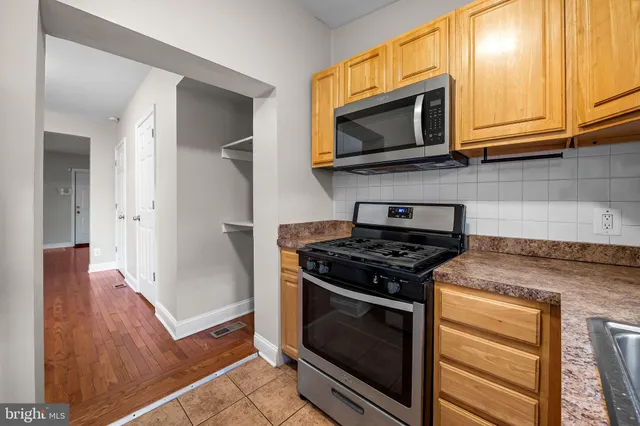 a kitchen with stainless steel appliances granite countertop a stove microwave and refrigerator