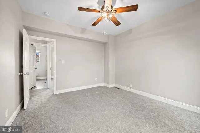 an empty room and chandelier fan