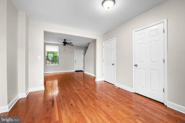 an empty room with wooden floor and windows