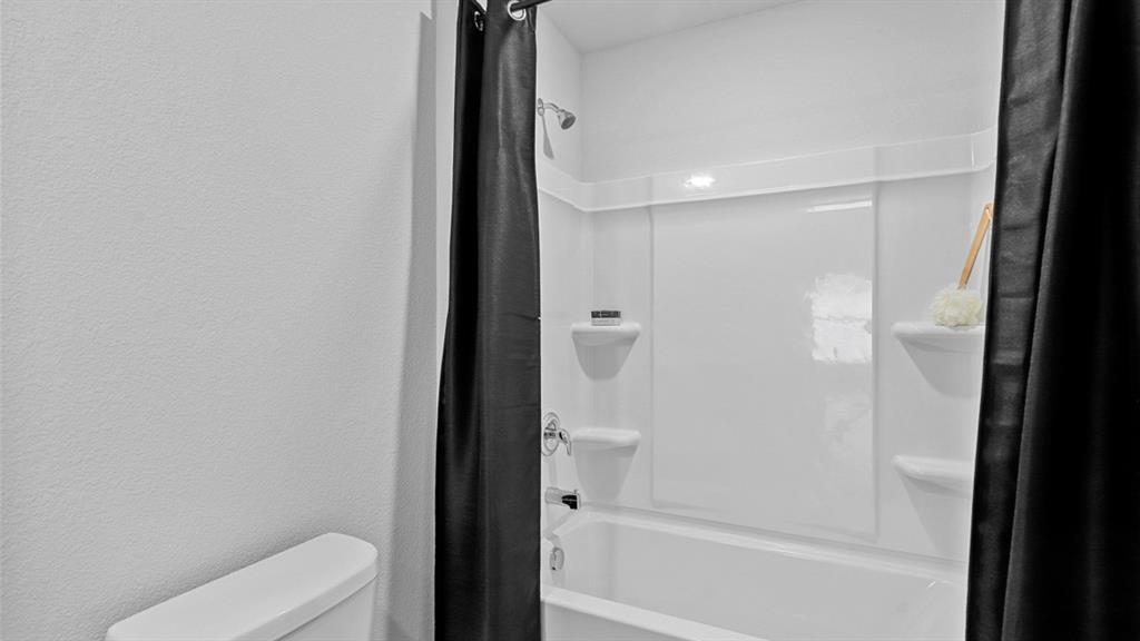 504 Marsh Street Cleburne, TX 76033 - Photo 32 of 39 a bathroom with a toilet and a shower