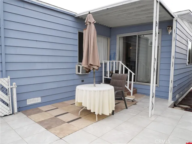 a view of two chairs and a table in the patio