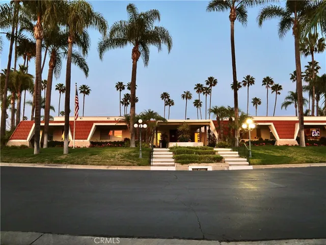a view of a house with a yard and palm trees