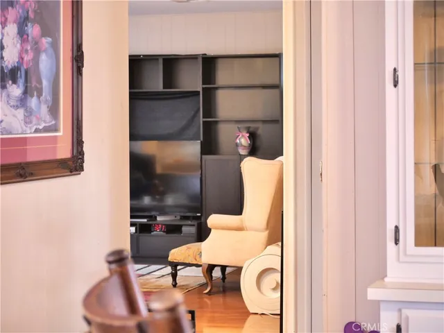 a living room with furniture kitchen view and a wooden floor
