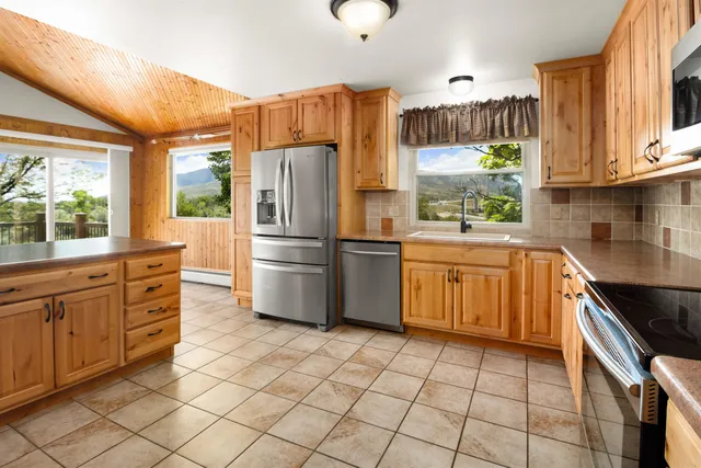 a kitchen with stainless steel appliances a refrigerator sink and cabinets