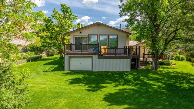 a front view of a house with yard and green space
